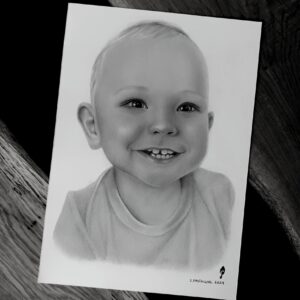 radosne dziecko uwiecznione na portrecie narysowanym ołówkiem na podstawie ze zdjęcia na zamówienie. Ręcznie rysowany portret na zamówienie – idealny prezent na ślub, dla przyjaciółki, mamy lub rodziców. Pamiątka z wesela, portret z kilku zdjęć lub renowacja starych zdjęć